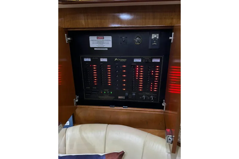 Slide: The Image of Electrical panel inside 2003 Cruisers Yachts 4370 Express, featuring illuminated switches and gauges. - 10