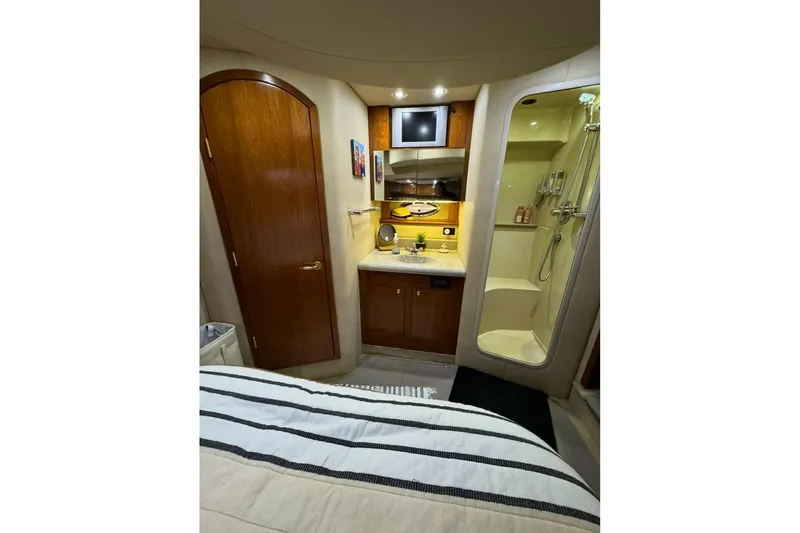 Slide: The Image of 2003 Cruisers Yachts 4370 Express interior with shower, sink, and wooden cabinetry. - 11