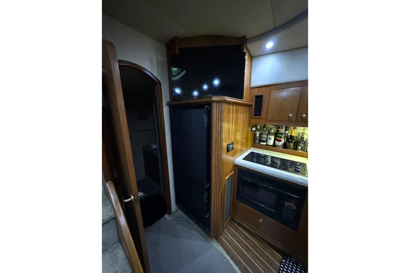 Slide: The Image of 2003 Cruisers Yachts 4370 Express interior with kitchen, cabinets, and appliances. - 16
