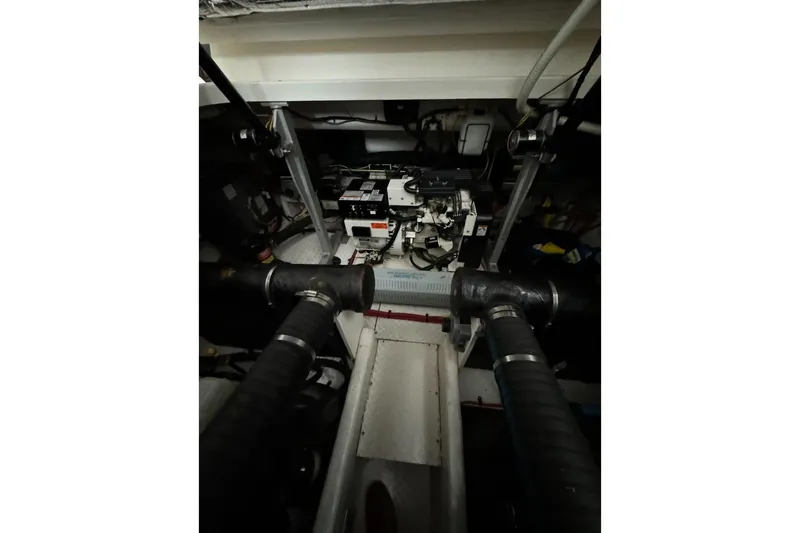 Slide: The Image of Engine room of 2003 Cruisers Yachts 4370 Express, featuring mechanical components and hoses. - 31