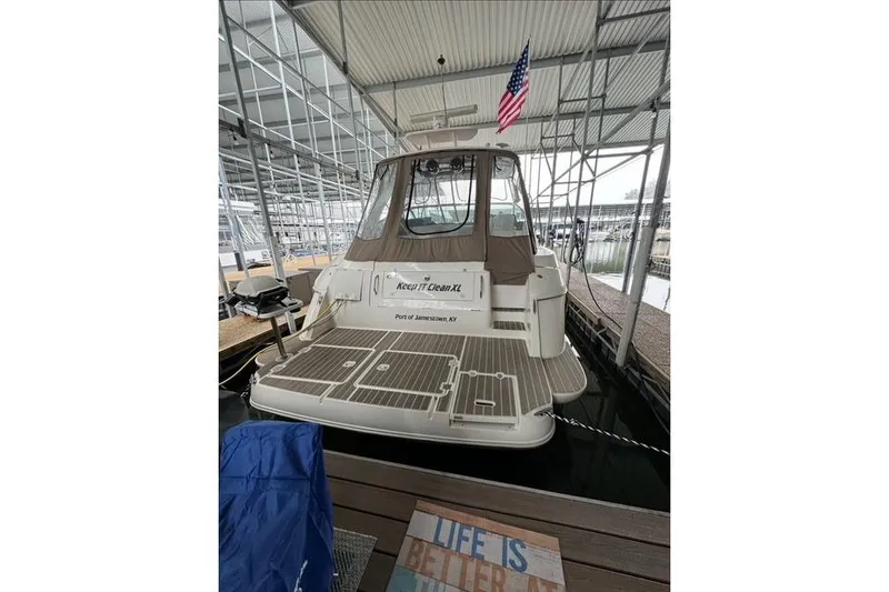 Slide: The Image of 2003 Cruisers Yachts 4370 Express docked, rear view with American flag, covered marina. - 5