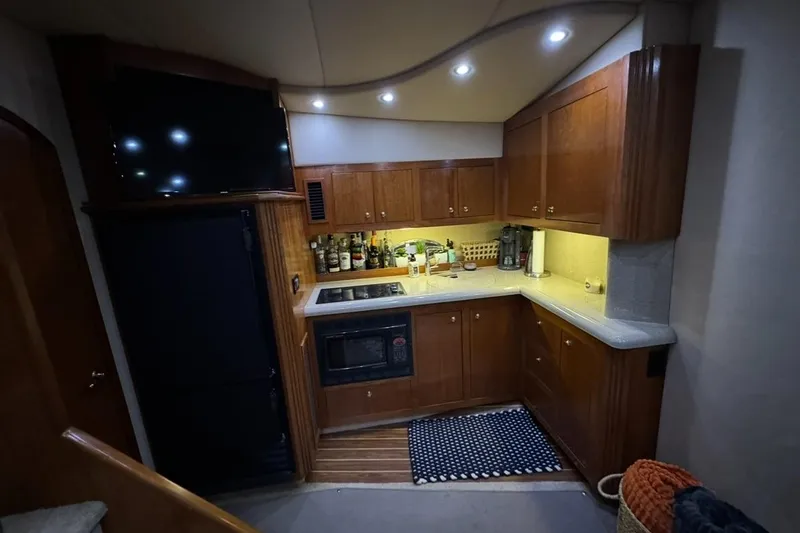 Slide: The Image of 2003 Cruisers Yachts 4370 Express kitchen with wooden cabinets and modern appliances. - 13