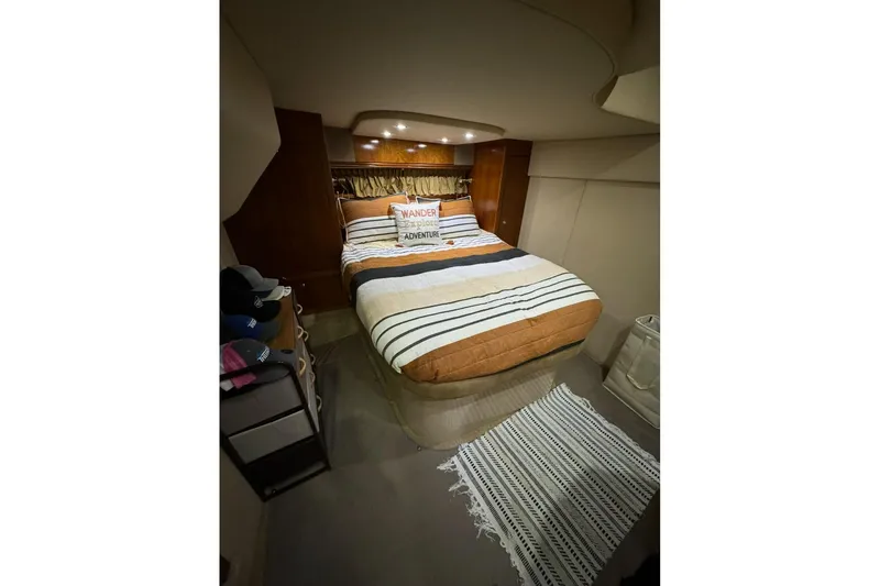 Slide: The Image of Cozy bedroom in 2003 Cruisers Yachts 4370 Express with striped bedding and ambient lighting. - 24