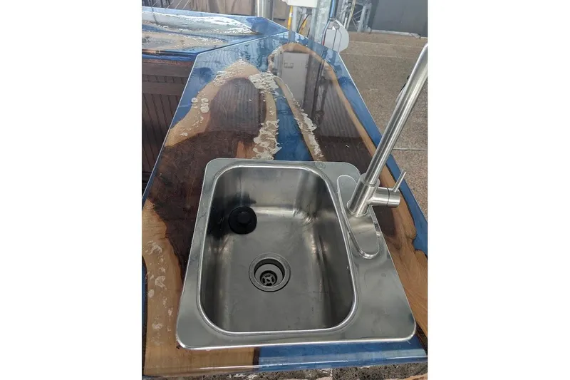 Slide: The Image of Stainless steel sink on a polished wooden countertop in a 2000 Sea Ray 380 Sundancer. - 10