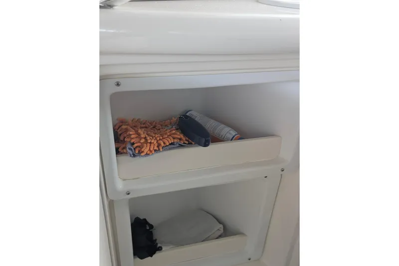 Slide: The Image of Storage compartment on a 2000 Sea Ray 380 Sundancer boat with cleaning supplies. - 14