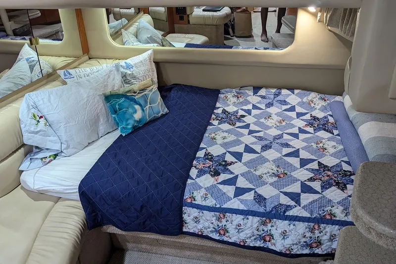 Slide: The Image of Cozy cabin interior of 2000 Sea Ray 380 Sundancer with patterned bedding and pillows. - 18