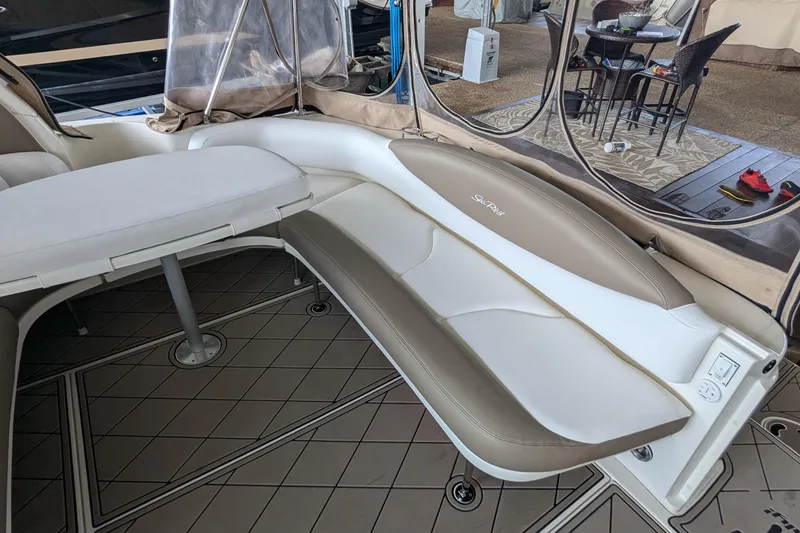 Slide: The Image of 2000 Sea Ray 380 Sundancer interior with cushioned seating and table in a covered area. - 25