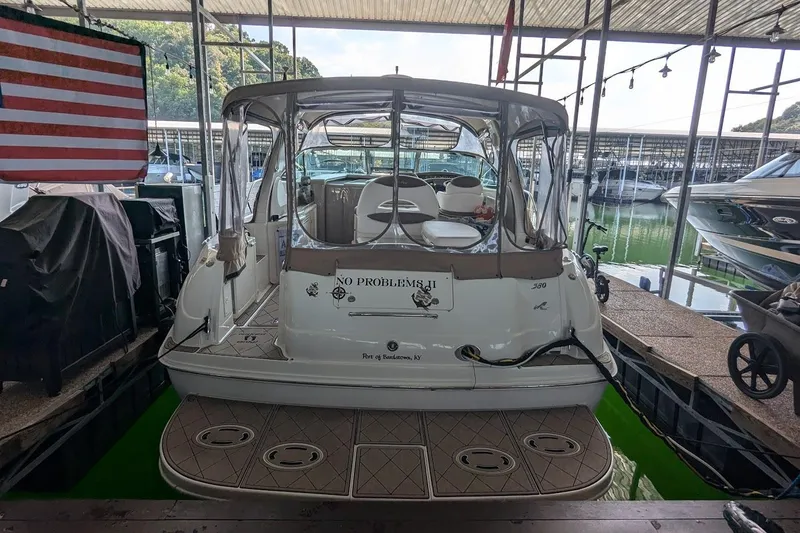 Slide: The Image of 2000 Sea Ray 380 Sundancer docked in marina, rear view with American flag. - 3