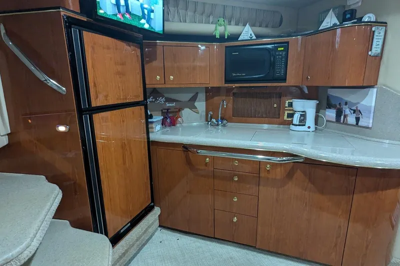 Slide: The Image of Interior of 2000 Sea Ray 380 Sundancer yacht kitchen with wood cabinets and appliances. - 9