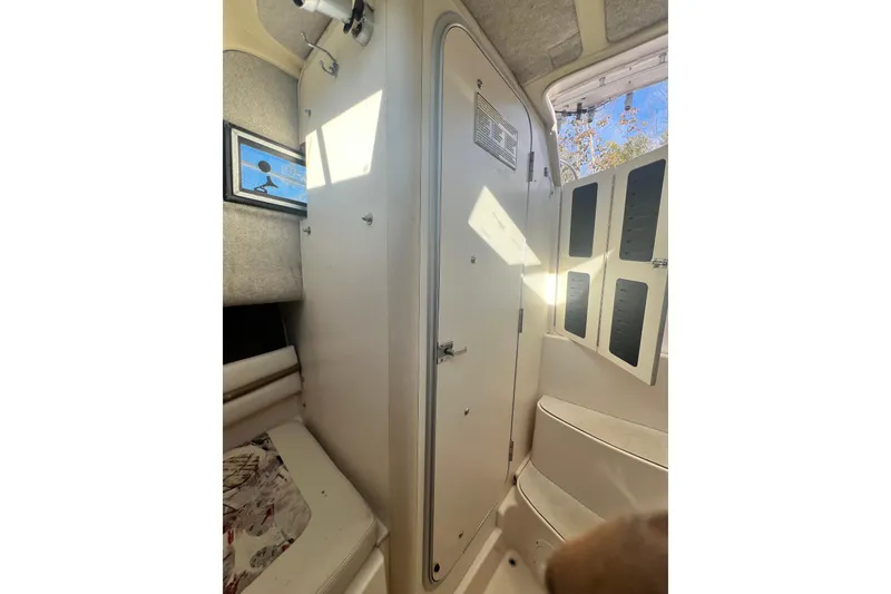 Slide: The Image of Interior of 1999 Grady-White Islander 268 boat, featuring cabin door and seating area. - 10