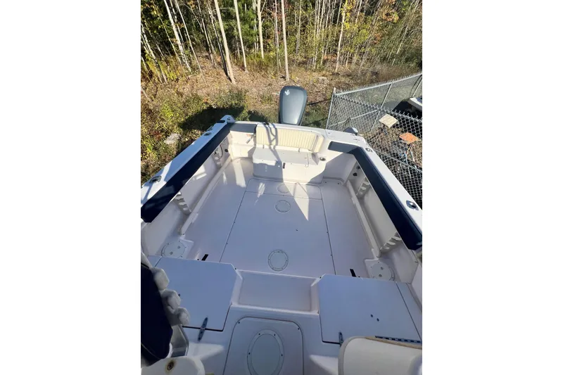 Slide: The Image of 1999 Grady-White Islander 268 boat deck with seating, surrounded by trees and a fence. - 11