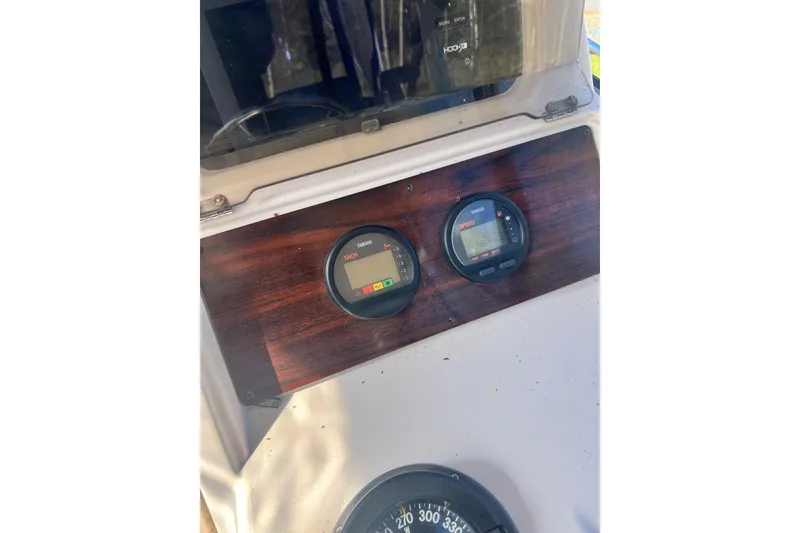 Slide: The Image of 1999 Grady-White Islander 268 dashboard with Yamaha tachometer and speedometer gauges. - 19