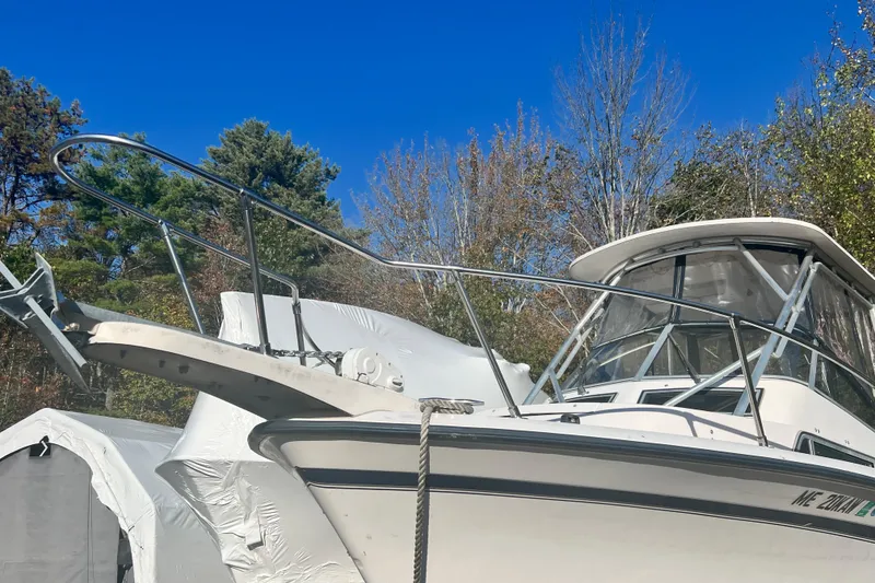Slide: The Image of 1999 Grady-White Islander 268 boat with canopy, docked outdoors under clear blue sky. - 3