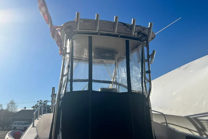 Slide: The Image of 1999 Grady-White Islander 268 boat with American flag, viewed from the stern under clear blue sky. - 4
