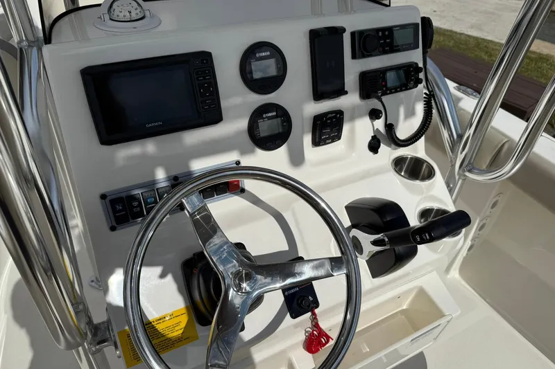 Slide: The Image of 2022 Key West 203 FS boat dashboard with steering wheel and navigation controls. - 10