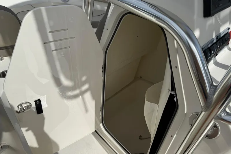 Slide: The Image of 2022 Key West 203 FS boat interior with open storage compartment and stainless steel railing. - 15