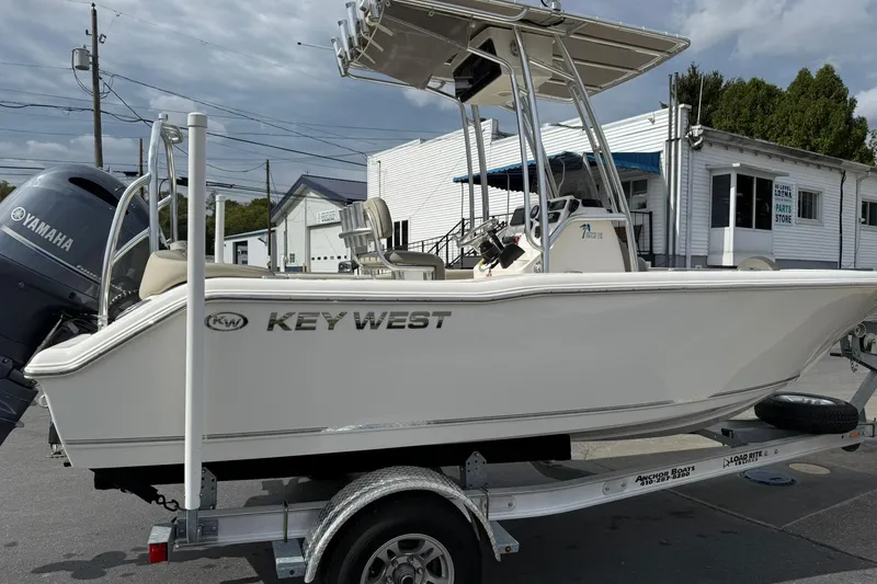 Slide: The Image of 2022 Key West 203 FS boat on trailer with Yamaha engine, parked near a building. - 5