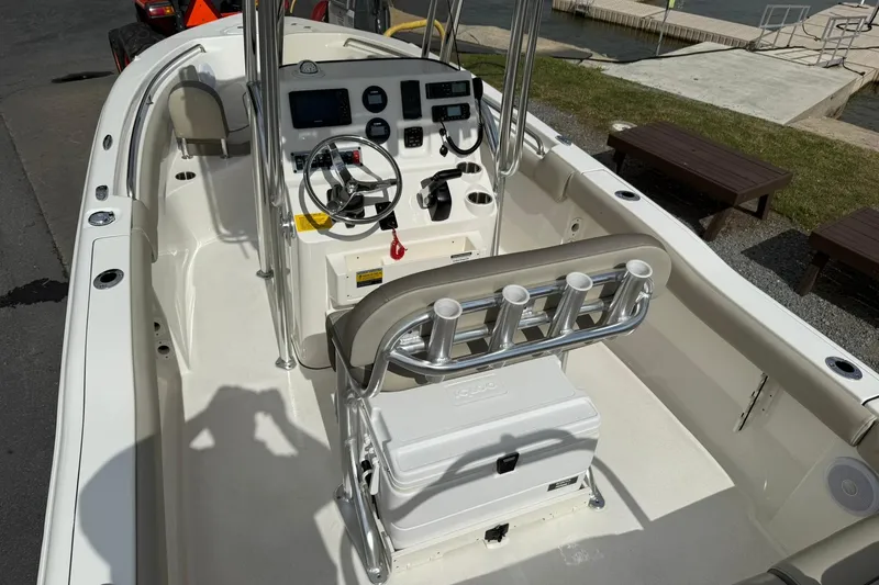 Slide: The Image of 2022 Key West 203 FS boat interior with steering console and rod holders, dockside view. - 7