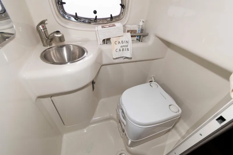 Slide: The Image of 2009 Sea Ray 250 Sundancer cabin bathroom with sink and portable toilet. - 12