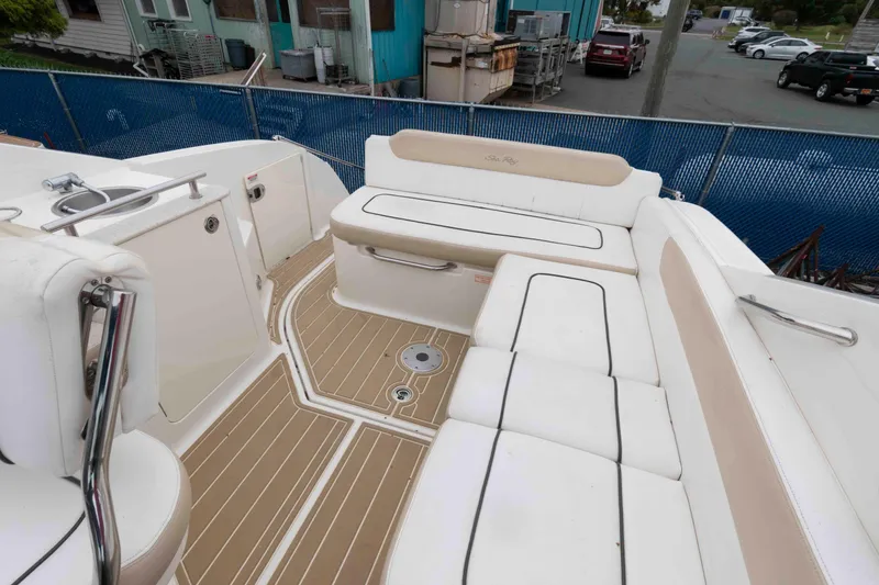 Slide: The Image of 2009 Sea Ray 250 Sundancer boat interior with white seating and wood-style flooring. - 3
