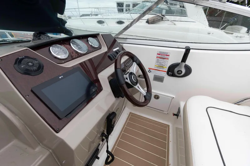 Slide: The Image of 2009 Sea Ray 250 Sundancer boat cockpit with steering wheel and control panel. - 4