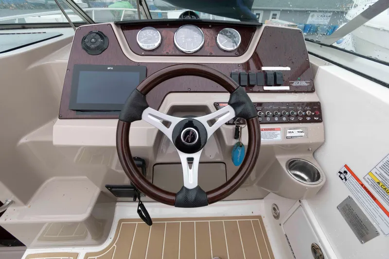 Slide: The Image of 2009 Sea Ray 250 Sundancer helm with steering wheel, gauges, and control panel. - 6