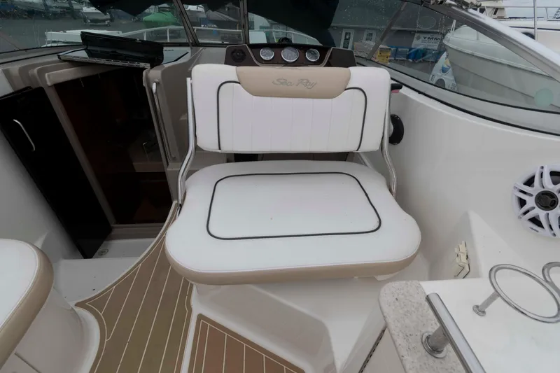 Slide: The Image of 2009 Sea Ray 250 Sundancer boat interior with white seating and dashboard. - 7
