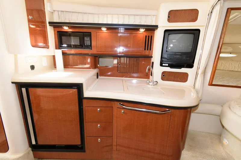 Slide: The Image of Interior of 2002 Sea Ray 340 Sundancer with beige seating and wooden table. - 14