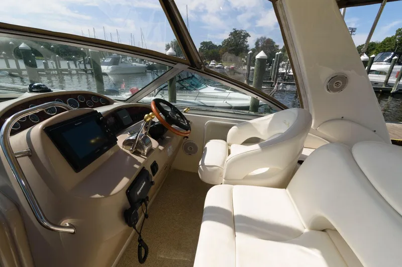 Slide: The Image of 2002 Sea Ray 340 Sundancer helm with white leather seats and modern controls. - 5