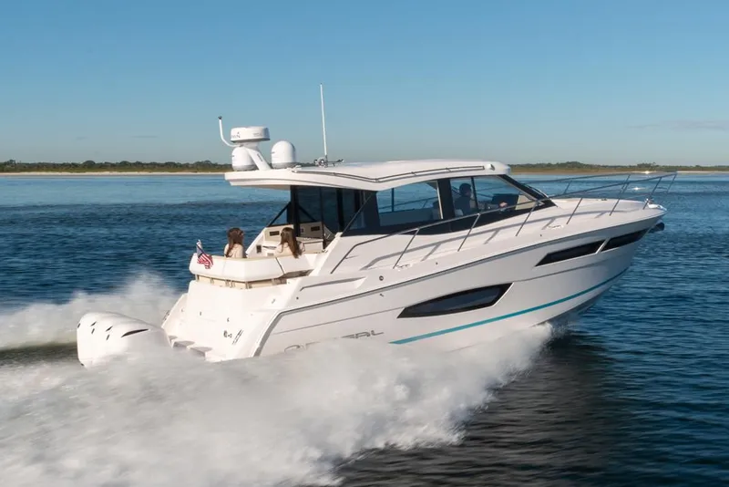 The Image of 2020 Regal 38 XO yacht docked at sunset, surrounded by calm water and trees. - 0