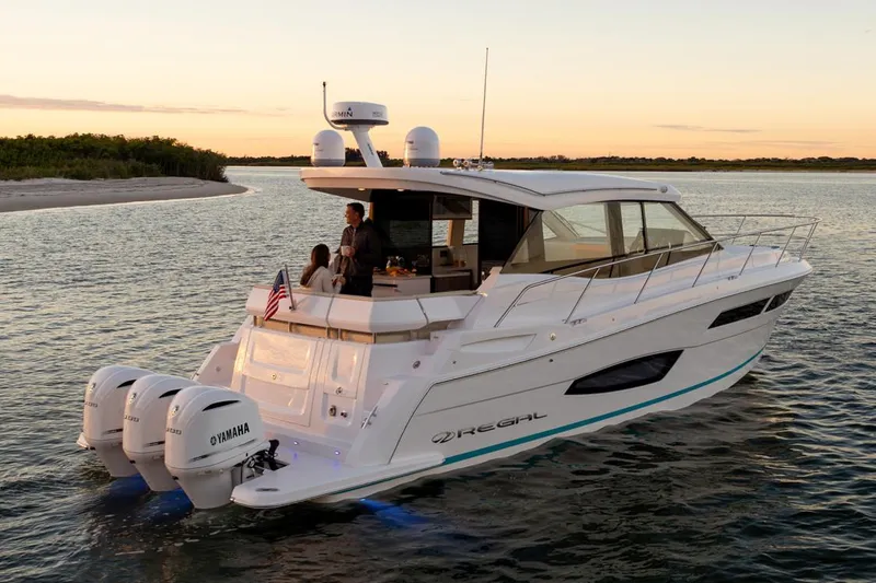 Slide: The Image of 2020 Regal 38 XO boat with Garmin radar, docked by a serene lake at sunset. - 3