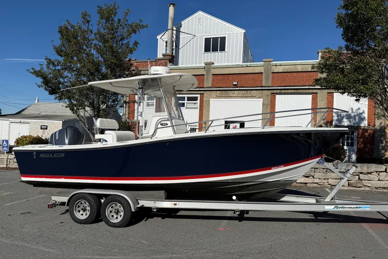 Slide: The Image of 2001 Regulator 23 Classic boat on trailer, parked near a brick building. - 3