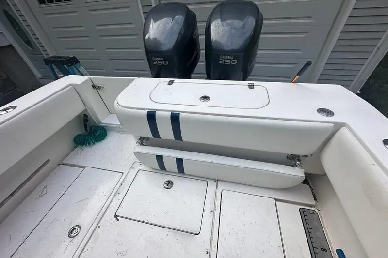 Slide: The Image of 2006 Contender 27 CC boat deck with Yamaha 250 engines, white seating, and storage compartments. - 11