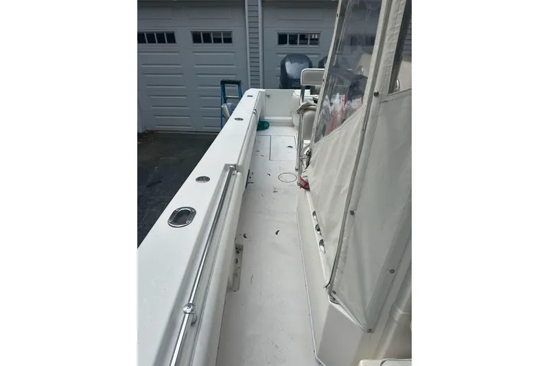 Slide: The Image of 2006 Contender 27 CC boat interior with white deck and covered seating area. - 13