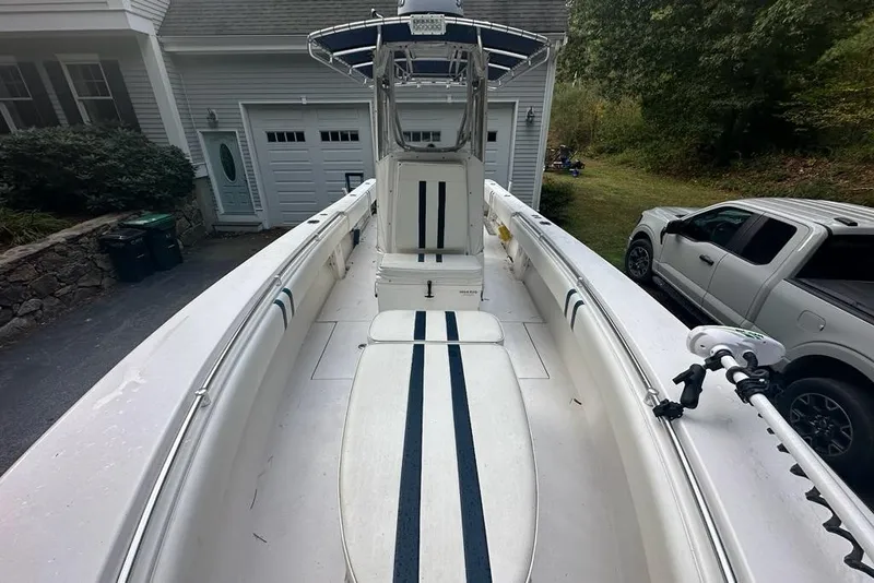 Slide: The Image of 2006 Contender 27 CC boat parked in driveway, featuring spacious deck and center console. - 8