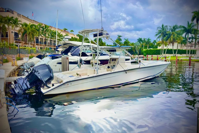 Slide: The Image of 1993 Marlin 35 CC Sportfish w/Cuddy docked at marina, surrounded by palm trees. - 2