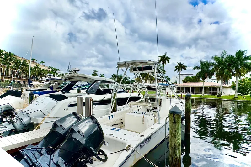 Slide: The Image of 1993 Marlin 35 CC Sportfish boat with twin outboard motors docked in marina. - 3