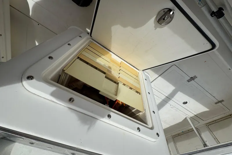 Slide: The Image of 1993 Marlin 35 CC Sportfish boat interior with striped seating and dual engines. - 55