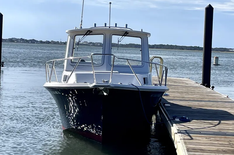 The Image of 2024 NorthCoast 235 boat docked by a wooden pier on a sunny day. - 0