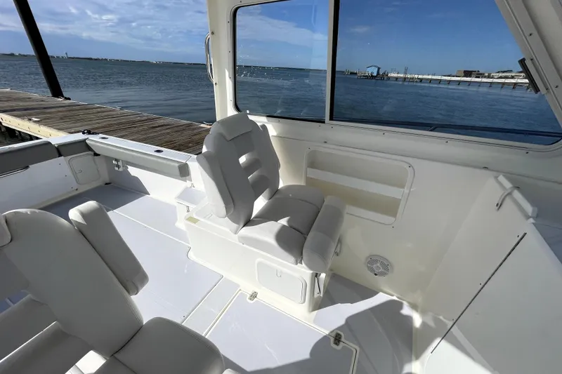 Slide: The Image of 2024 NorthCoast 235 boat interior with white seating and ocean view. - 17