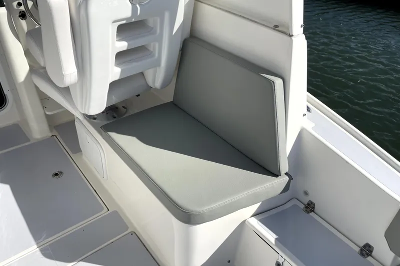 Slide: The Image of 2024 NorthCoast 235 boat interior with cushioned seating and water view. - 21