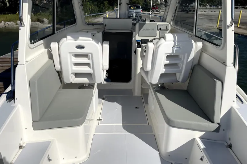Slide: The Image of 2024 NorthCoast 235 boat interior with seating and Garmin navigation system. - 22