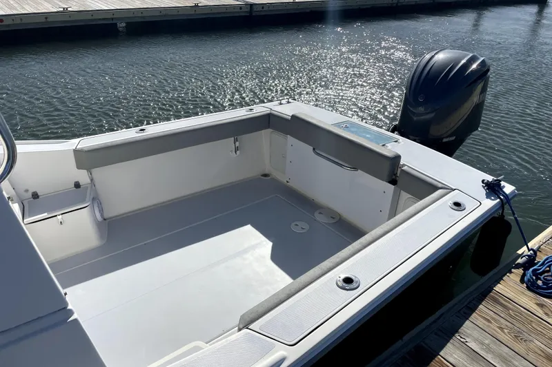 Slide: The Image of 2024 NorthCoast 235 boat at dock, featuring spacious deck and powerful outboard motor. - 23