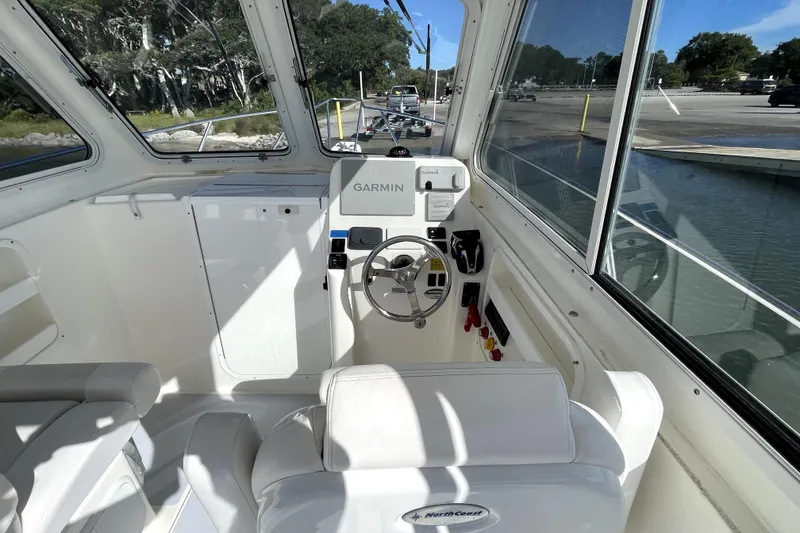 Slide: The Image of 2024 NorthCoast 235 boat interior with Garmin navigation system and steering wheel. - 24