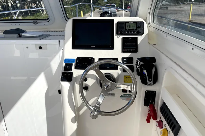 Slide: The Image of 2024 NorthCoast 235 boat helm with steering wheel and navigation controls. - 25
