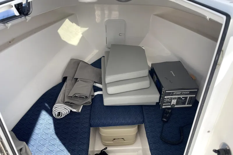Slide: The Image of 2024 NorthCoast 235 cabin interior with cushions, rolled fabric, and GPS equipment. - 6