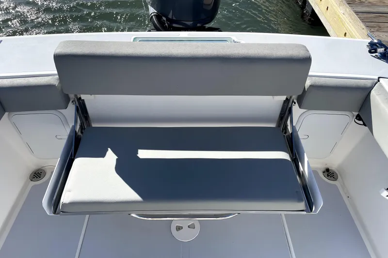 Slide: The Image of 2024 NorthCoast 235 boat with foldable seating, docked by the water. - 8