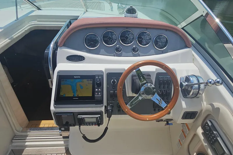 Slide: The Image of 2006 Chris-Craft Corsair 36 cockpit with wooden steering wheel and navigation instruments. - 13