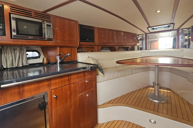Slide: The Image of Luxurious 2006 Chris-Craft Corsair 36 interior with wood cabinetry and cozy seating area. - 19