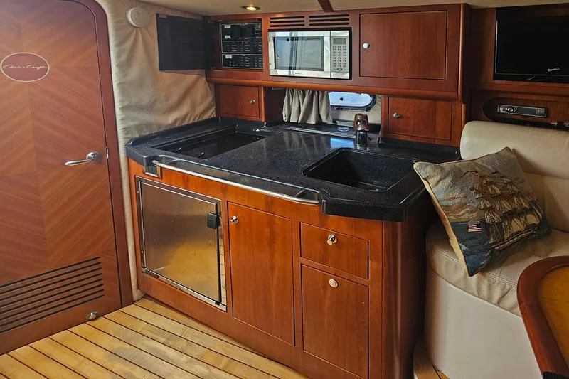 Slide: The Image of Luxurious 2006 Chris-Craft Corsair 36 yacht interior with elegant wooden cabinetry and modern amenities. - 22